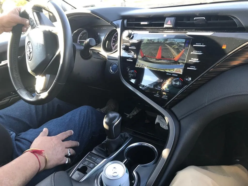 Student's hand on the gear selector of the automatic training car