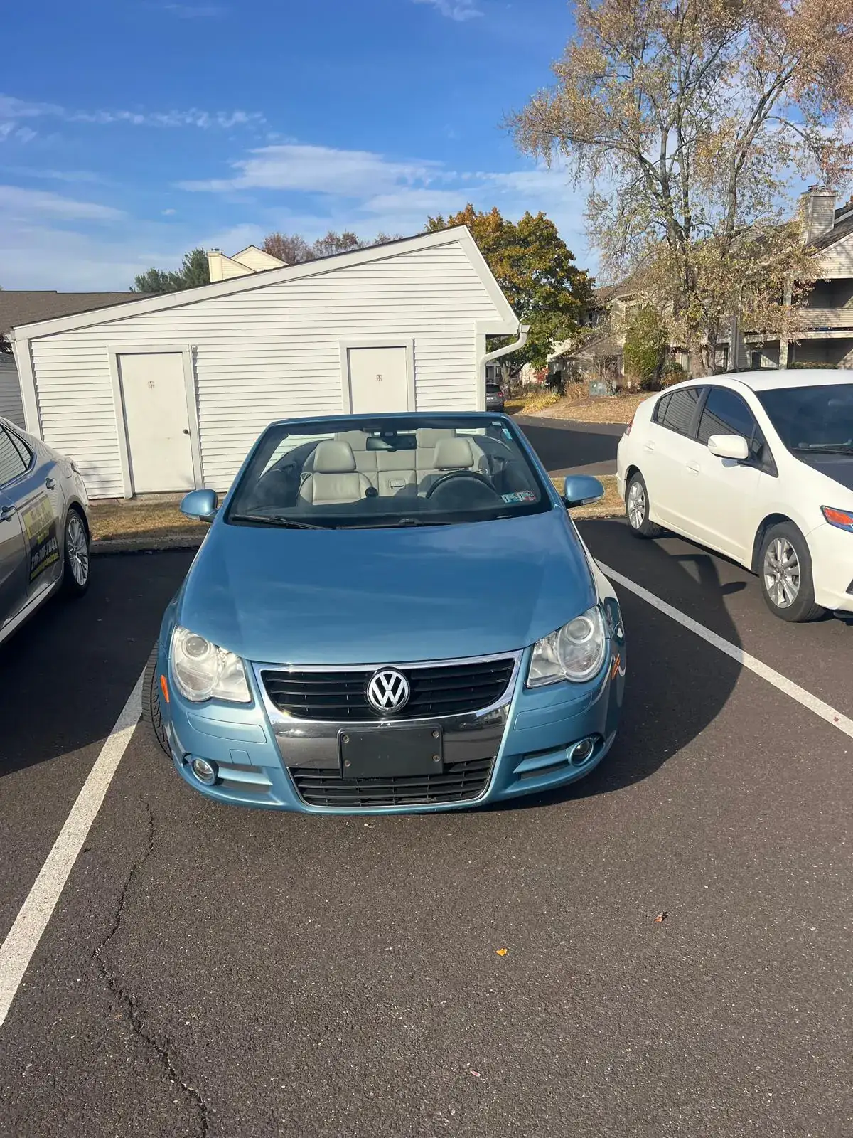 Light blue training car parked next to a white car in a practice lot