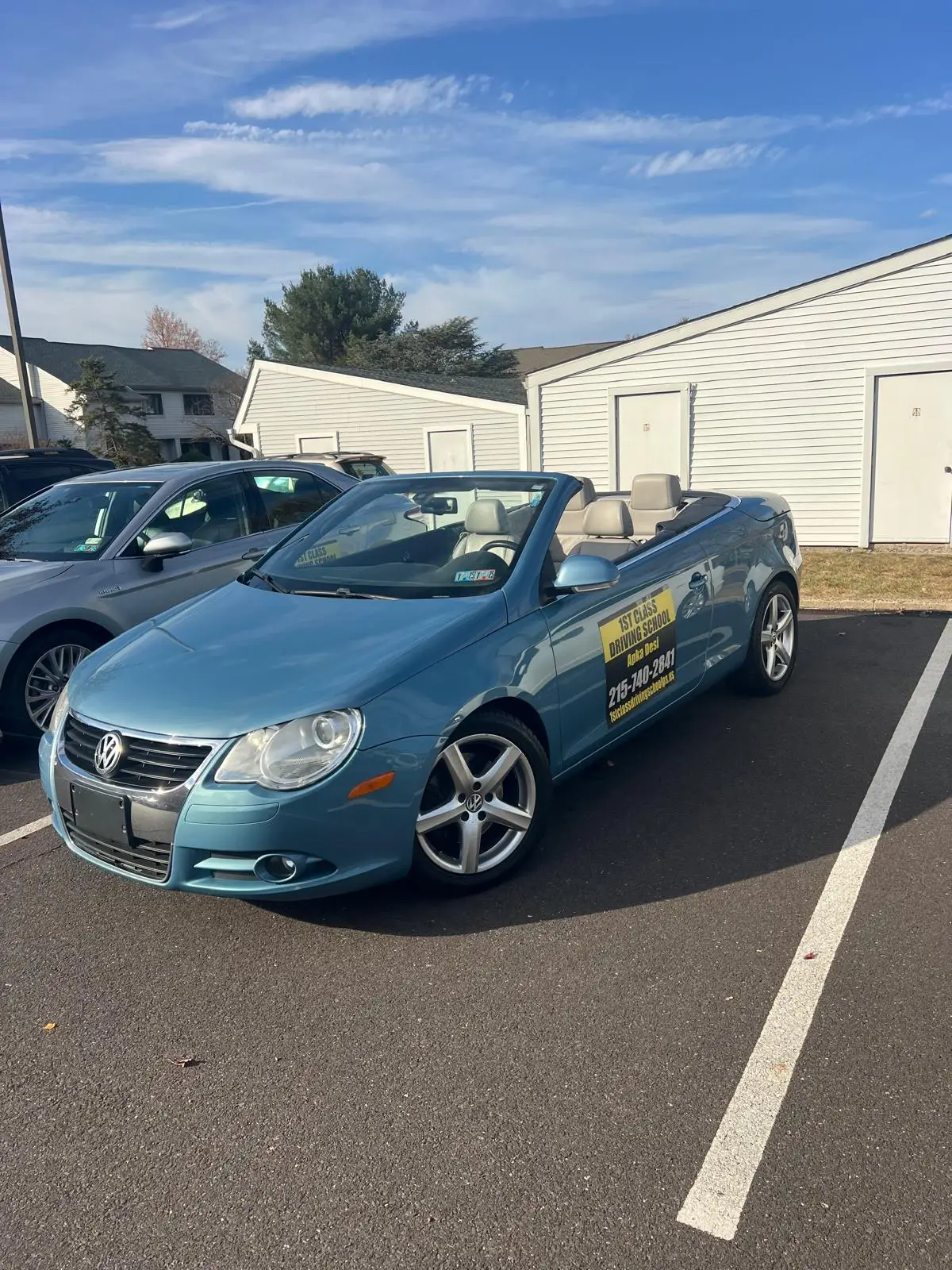 Light blue training car parked in a quiet lot used for maneuver practice