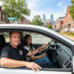 A nervous but hopeful student sitting in the driver's seat of a 1st Class Driving School car in Philadelphia.